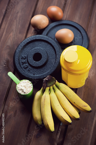 Shaker, weight plates, scoop of protein, bananas and hen eggs