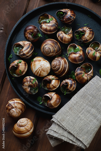 Escargots de Bourgogne in a frying pan, above view, close-up