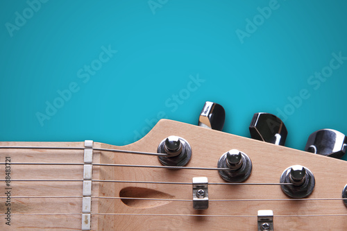 Head of electric guitar on blue background