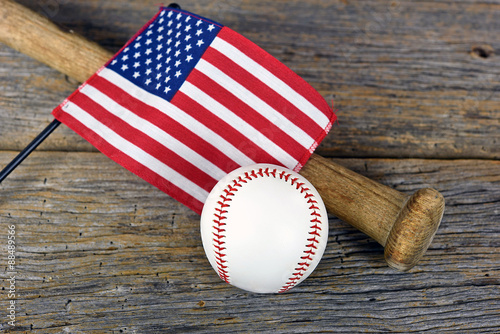American flag on wooden bat with baseball on rustic barn wood