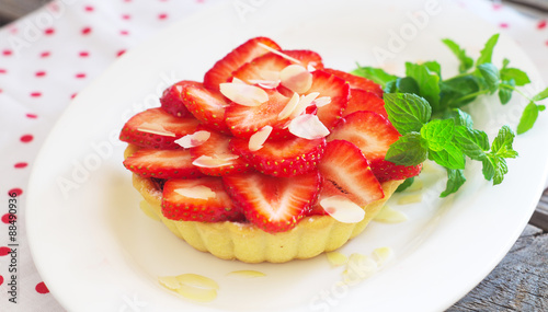 strawberry cake with fresh mint leaves on the wooden surface. Selective focus