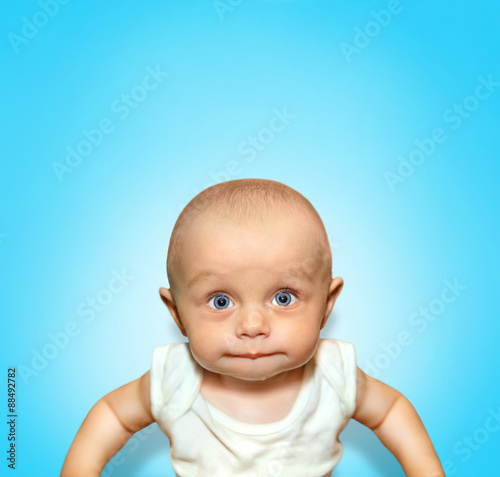 Funny portrait of an adorable baby boy sucking lips with blue
