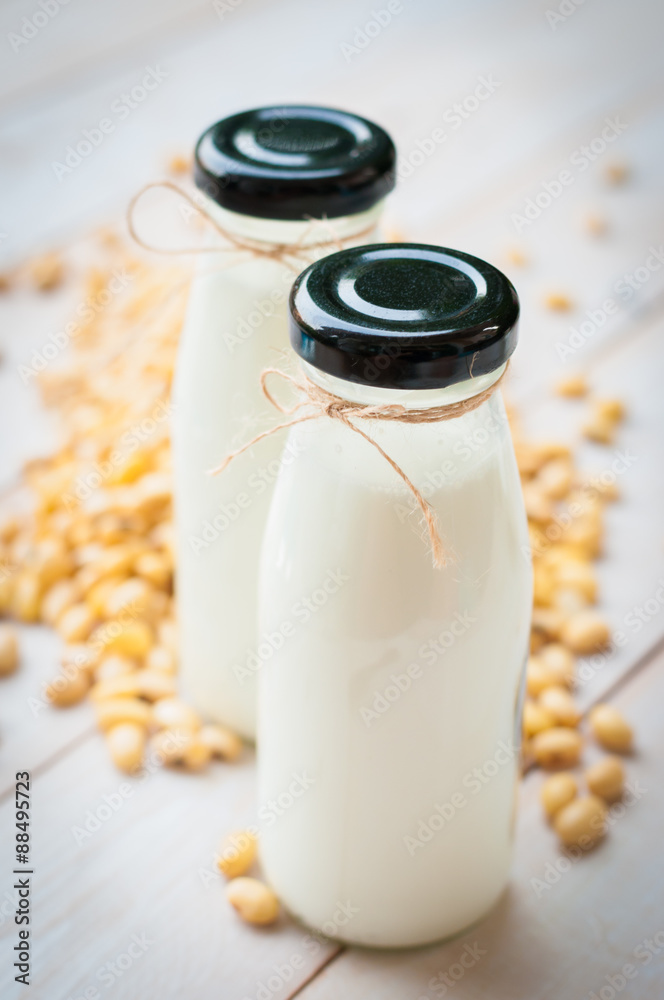 Soy milk [Soya milk ] in  glass bottle with soy pods on white wo