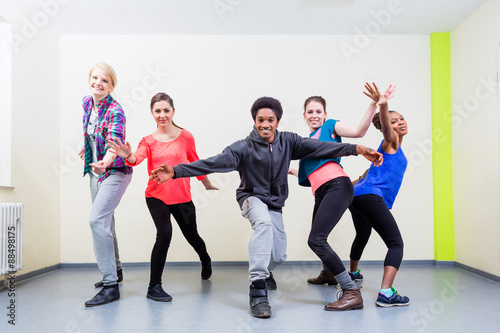 Group of young people having dance class in gym © Kzenon