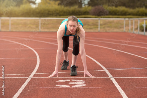 Young woman sprinter in the starter position