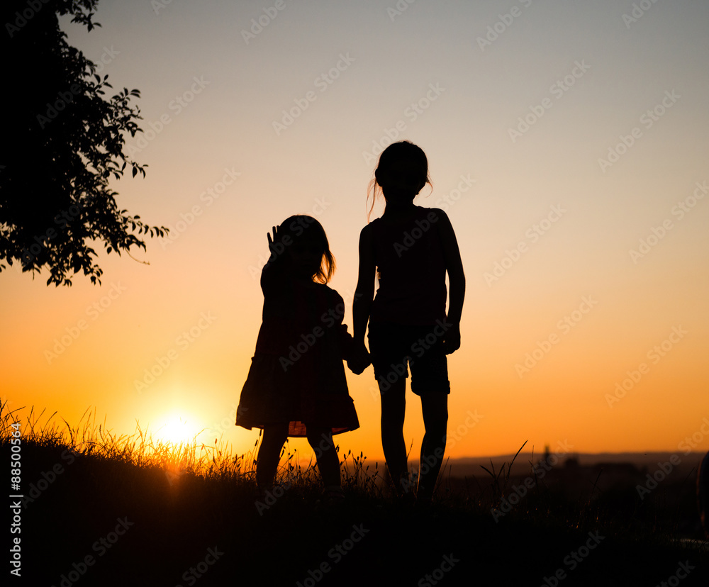 Silhouette of two young sisters 