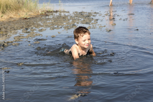 Fototapeta Naklejka Na Ścianę i Meble -  Boy lying in the healthy mud