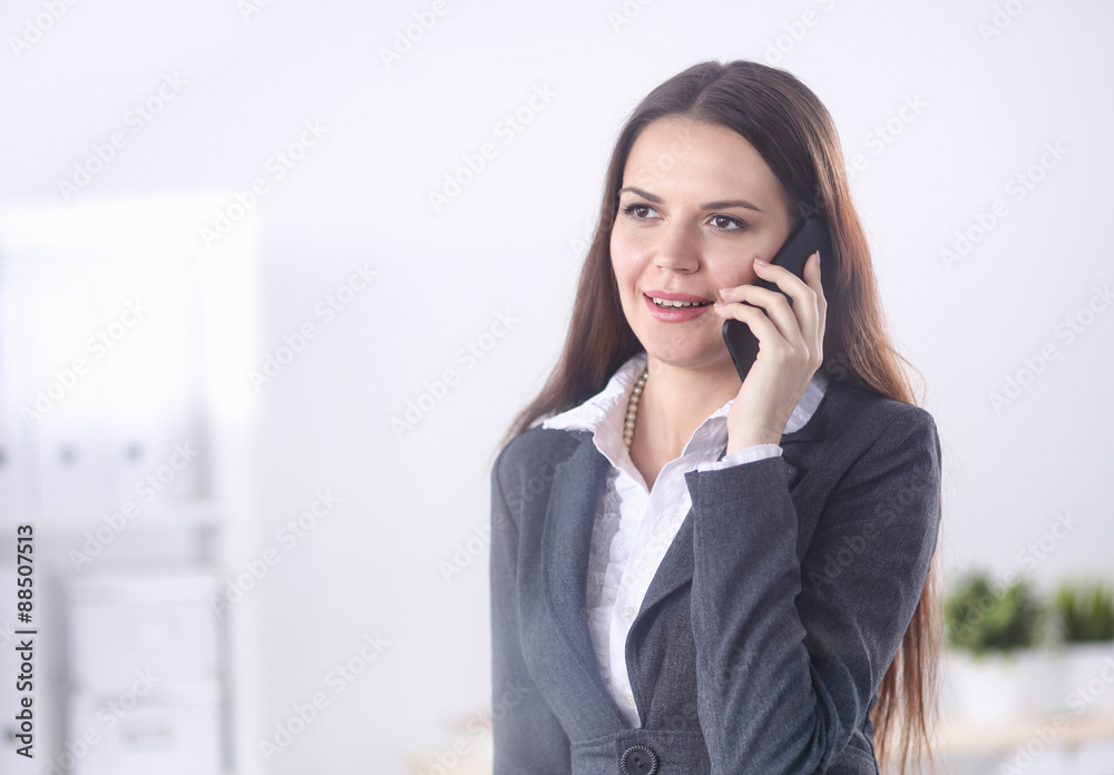 Smiling businesswoman talking on the phone at the office Smiling businesswoman talking on the phone at the office