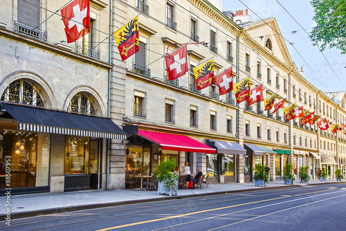 Geneva city street Rue Carraterie  view in summer with swiss flags on the street