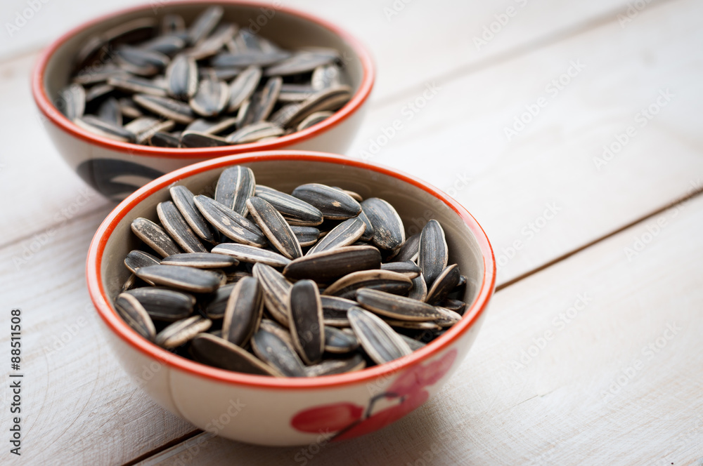 Close up sunflower seed in ceramic dish isolated on white Close up sunflower seed in ceramic dish isolated on white