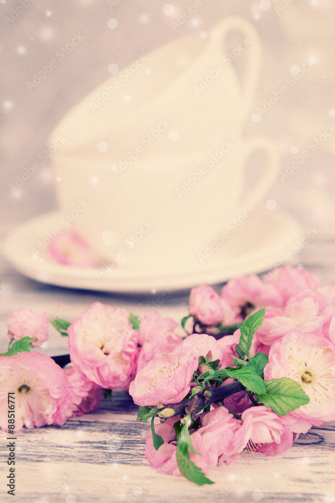 Beautiful fruit blossom and tea cups on table