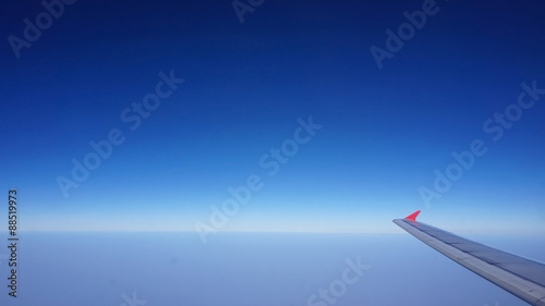 plane wing with blue horizontal skyline with no cloud