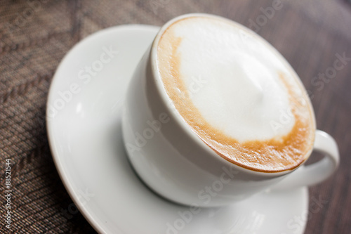 Cup of cappuccino over wooden table