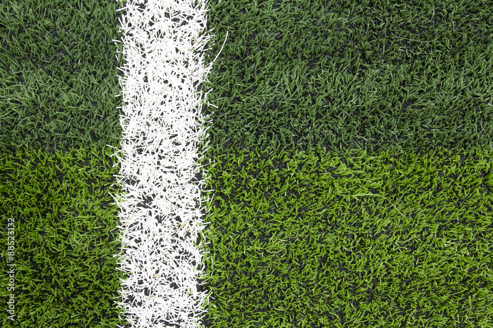Obraz premium Photo of a green synthetic grass sports field with white line sh