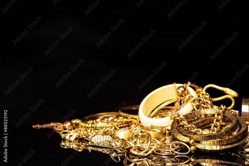 Bunch of gold jewelry against black background with copy space for text.  Stock Photo | Adobe Stock