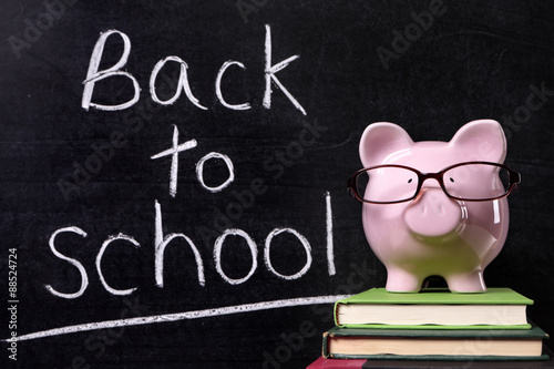 Piggy Bank with back to school message written in chalk on a blackboard school college fund saving money photo