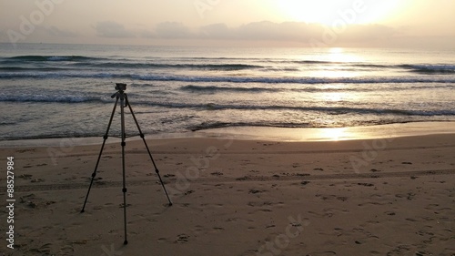 Photographer trypod facing the sunrise on the beach