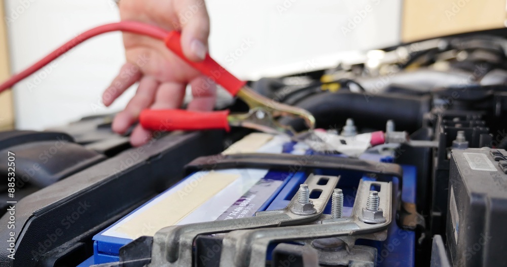I need the booster cables / A person connects the booster cables to the car battery I need the booster cables / A person connects the booster cables to the car battery