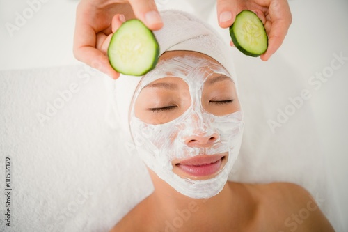 Woman placing cucumber on patient eye