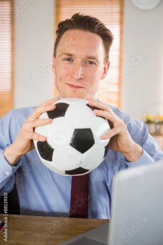 Cheerful businessman holding a soccer ball