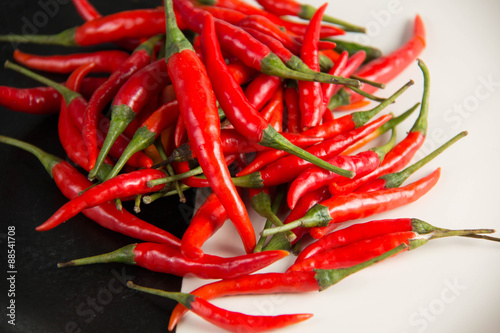  fresh raw red hot chili peppers on plate.