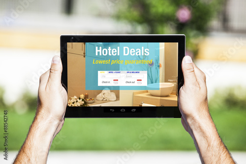 Hotel Deals on tablet. Web template design. Luxury bathroom in the background.
