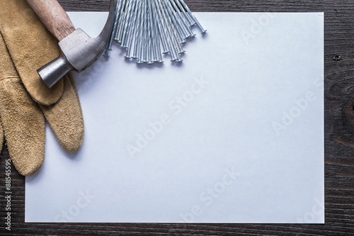 Sheet of paper stainless nails claw hammer and leather protectiv