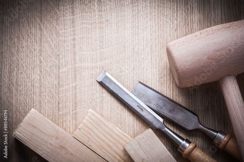 Wooden bricks mallets flat chisels on wood background close up v