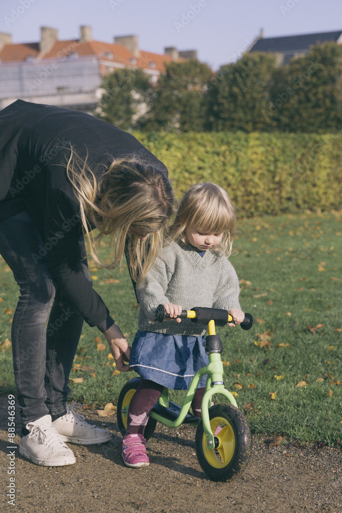 Mother teaching her daughter to ride a bicycle Mother teaching her daughter to ride a bicycle
