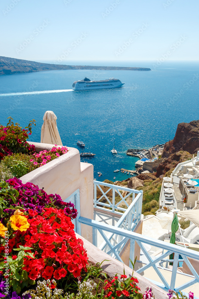 Obraz premium Flowers, buildings and cruise ship in Oia, Santorini