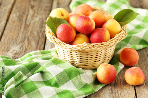 Fresh apricots in basket on a grey wooden background