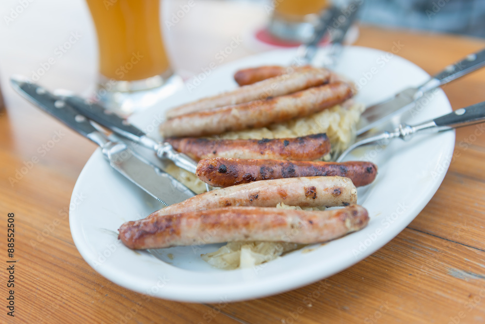 Sausage with cabbage on white plate. Selective focus. Sausage with cabbage on white plate. Selective focus.