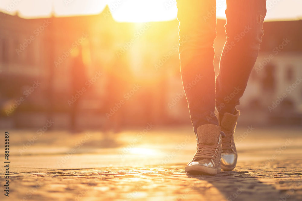 Fototapeta premium Womansfoots on the street at sunny day.