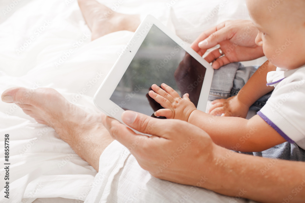 Young father and his nine months old son with digital tablet Young father and his nine months old son with digital tablet