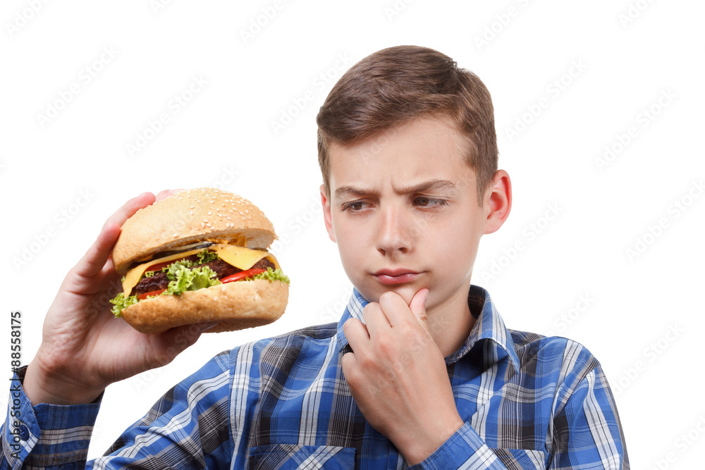Boy looks at a cheeseburger and thinking. Boy looks at a cheeseburger and thinking.