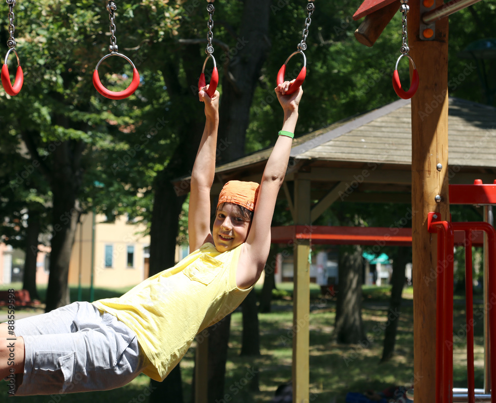 Fototapeta premium child plays with rings of outdoor playground