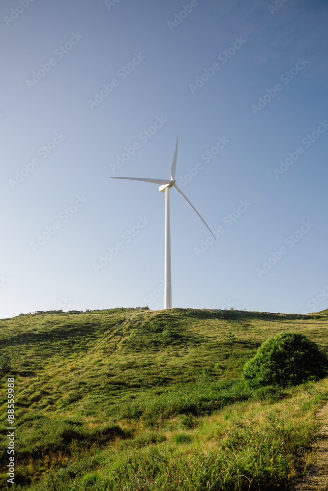Wind turbine generating electricity over blue sky background Wind turbine generating electricity over blue sky background