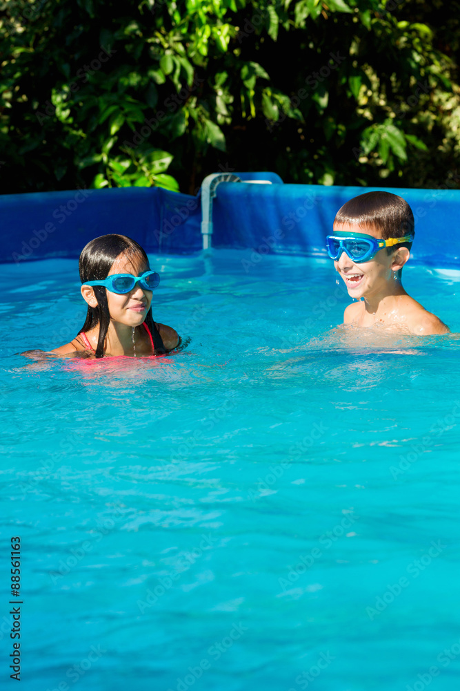 Young boy and girl in swimming pool Young boy and girl in swimming pool