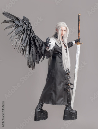 Fantasy woman warrior / Woman warrior with sword and wings isolated on the gray background photo