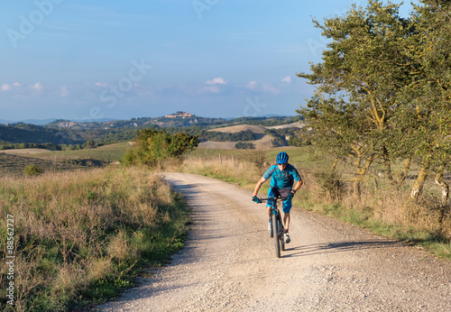 Mountain biker riding through Tuscan landscape
