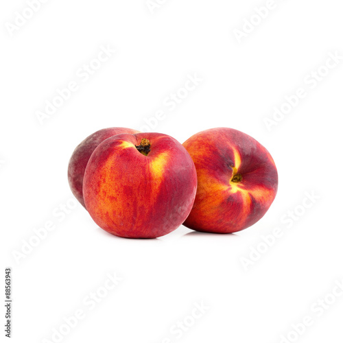 Three peaches on white table