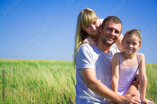 Young happy family in a field of a mom dad daughter © svrsstudio