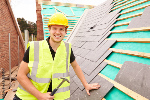 Bild auf Leinwand Construction Worker On Building Site Laying Slate Tiles