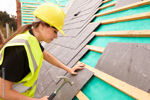 Foto Female Construction Worker On Site Laying Slate Tiles