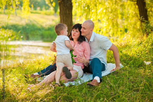 Happy joyful young family with child outdoors
