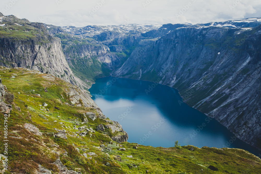 Naklejka premium Beautiful norwegian vibrant summer landscape with fjord, mountain and lake, lake Ringedalsvatnet on the way to famous Trolltunga, Skjegeddal rock, near Odda, Hordaland, Norway.