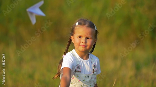 The small girl hold and launch paper airplane not successfully. Slow motion photo