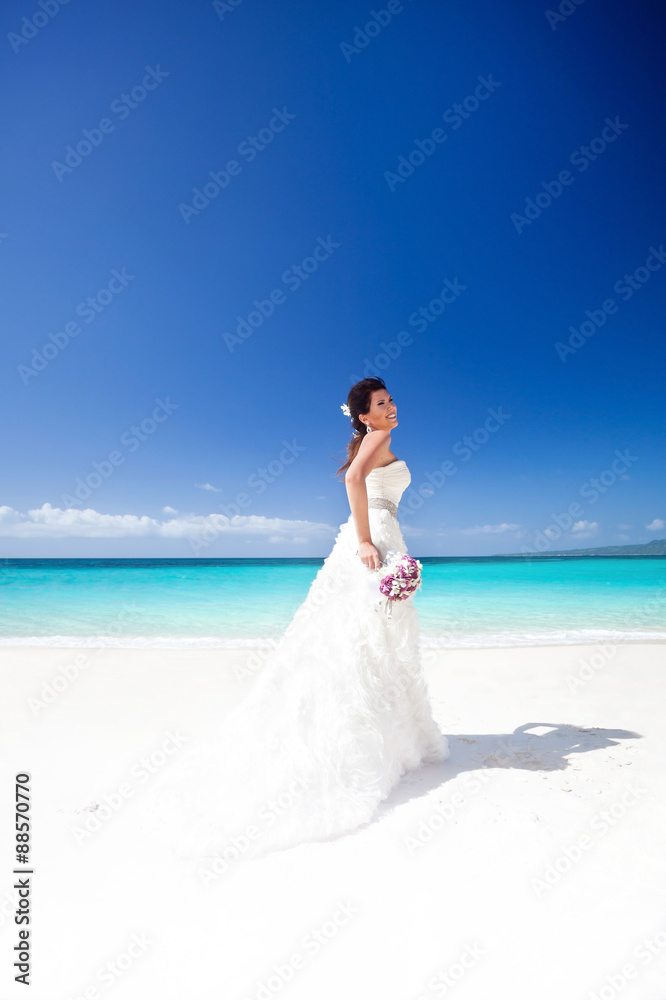 Beautiful bride on white sandy beach, smiling and feeling happin Beautiful bride on white sandy beach, smiling and feeling happin