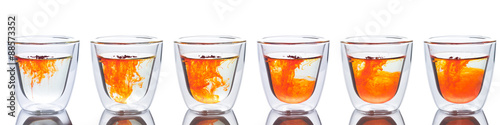 orange color spread in glass of water. show six step of it spread in to water
