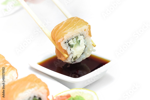 Sushi roll Philadelphia in chopsticks